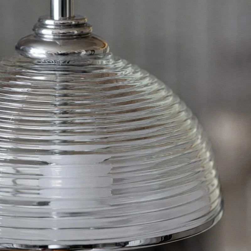 Close detail of the clear glass shade profile and metal hardware