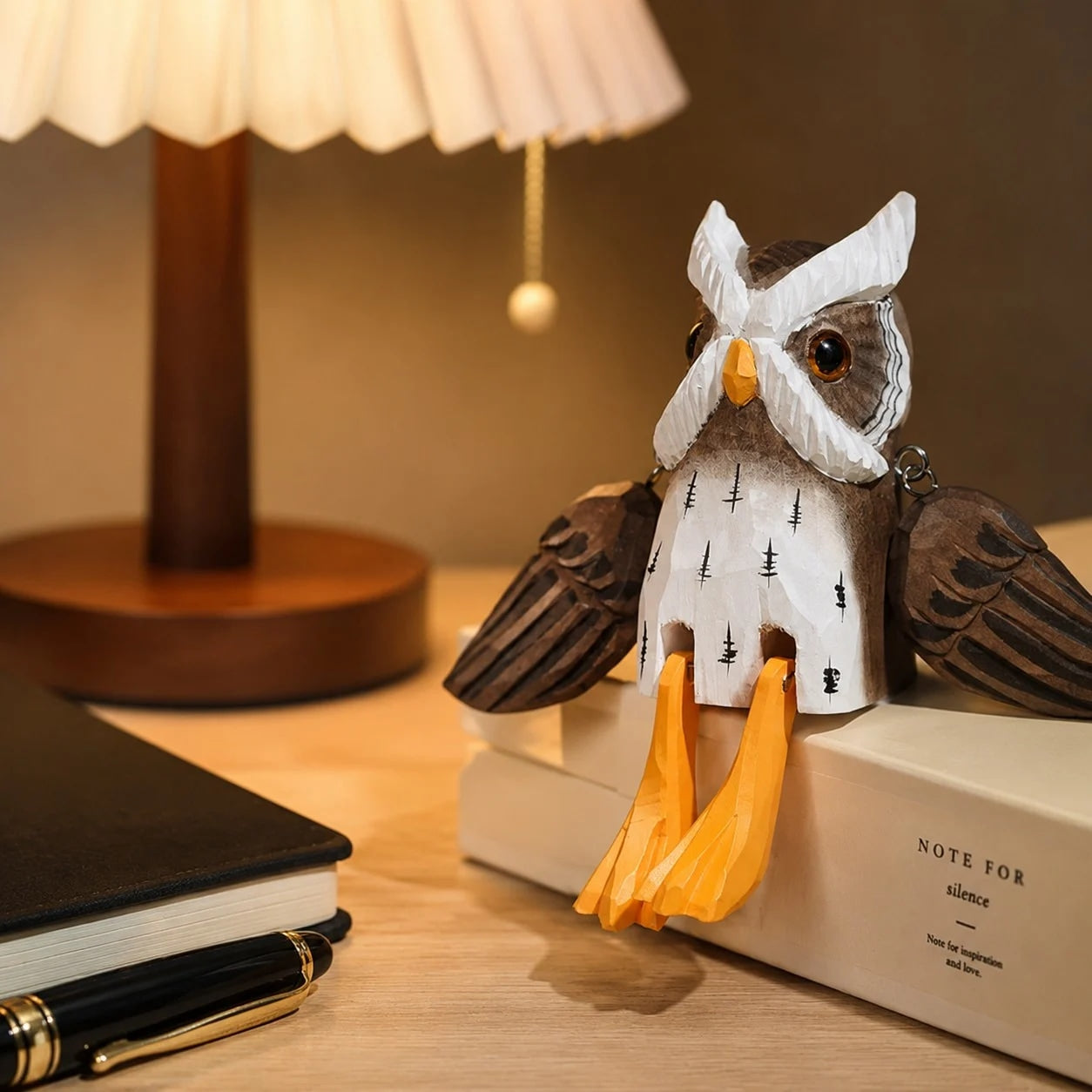 Hand-carved wooden hanging-leg owl ornament styled on a tabletop edge