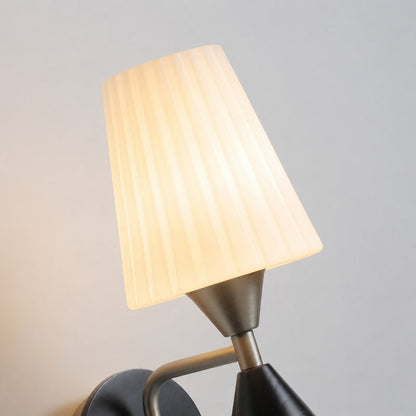 Glass shade and wall arm detail of matte nickel wall sconce