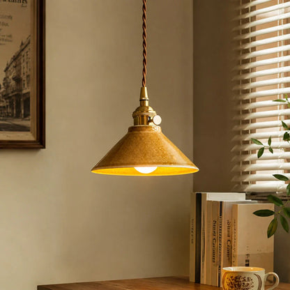 Yellow ceramic pendant light by a warm window corner