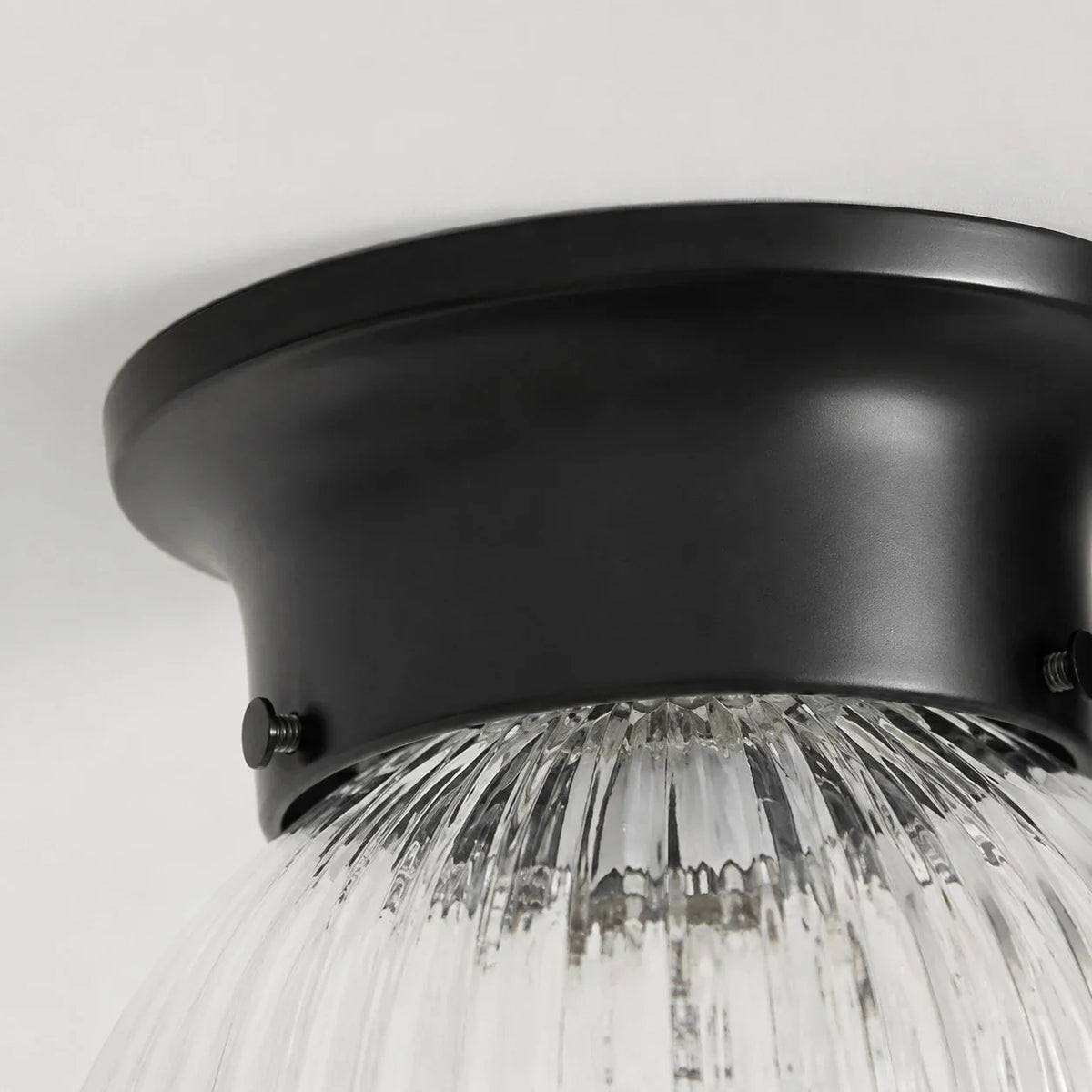 Close detail of black metal ceiling canopy and glass shade connection