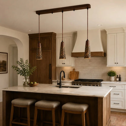 Three hammered copper pendant lights above a kitchen island