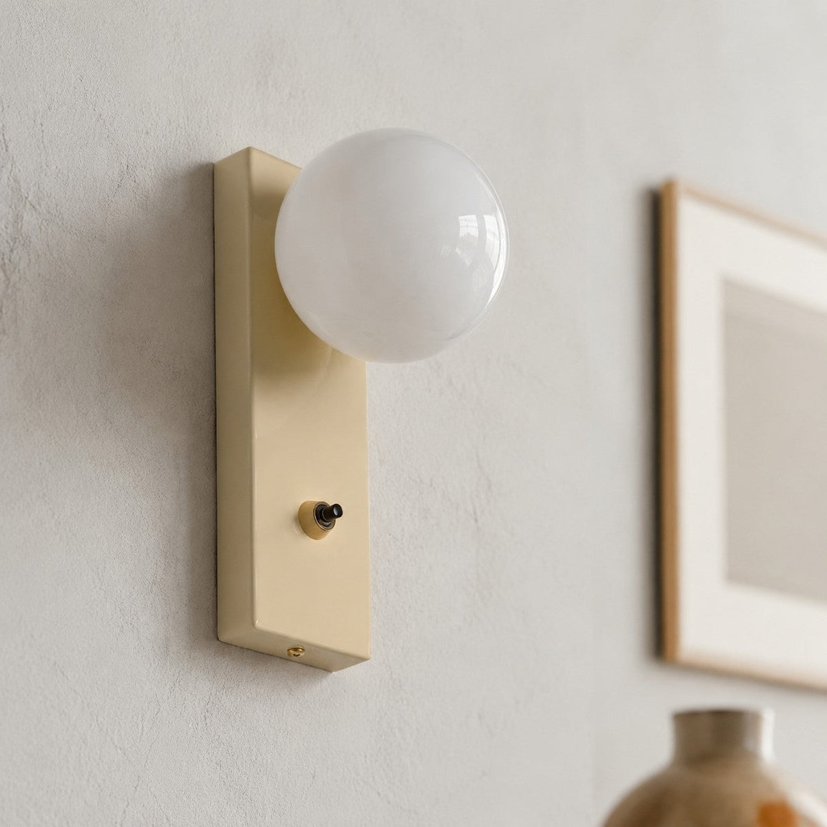 Close view of installed cream glass globe wall sconce