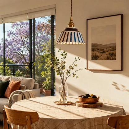 Striped ceramic pendant lamp in a sunlit dining nook