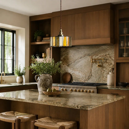 Brass glass pendant light over a marble kitchen island