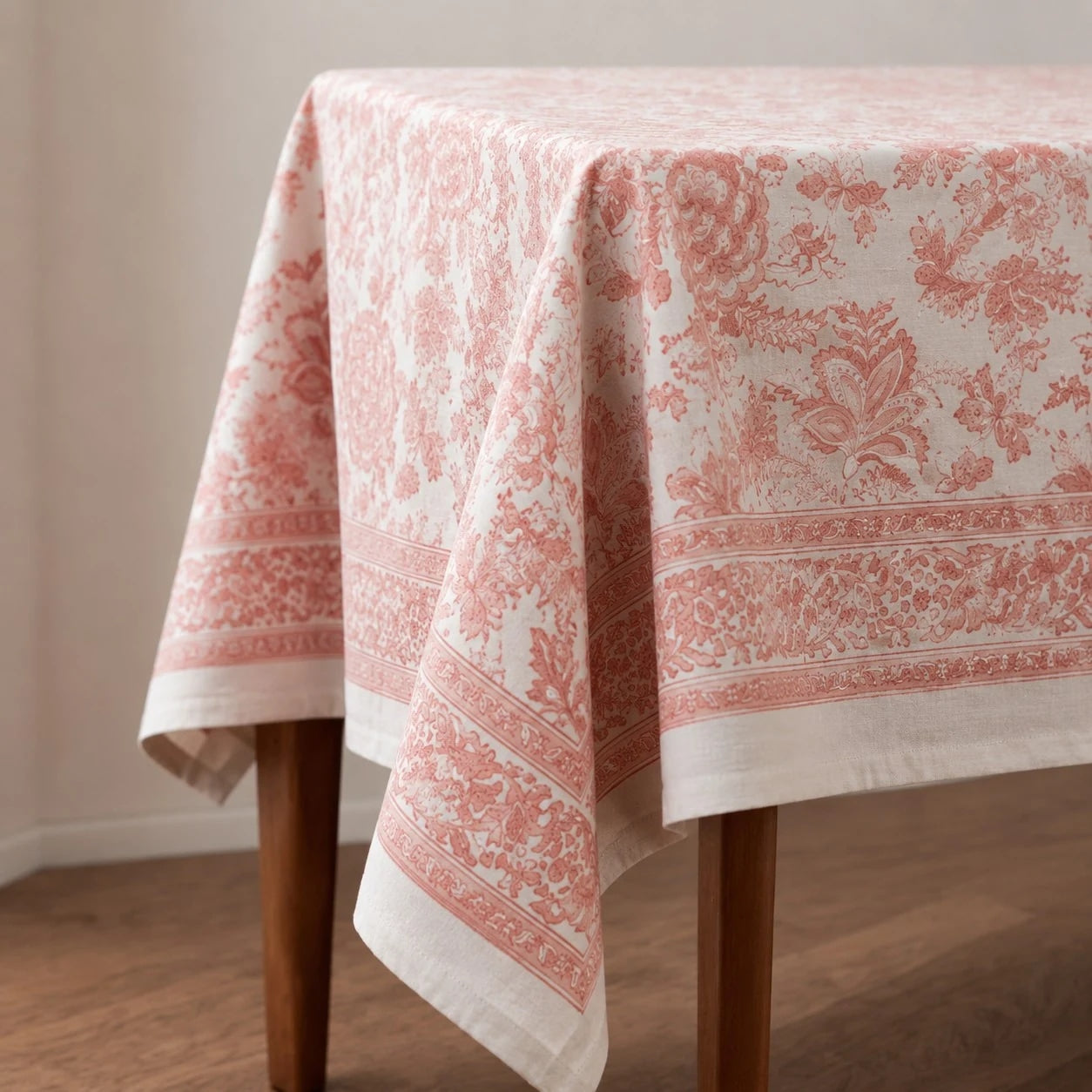 Soft coral floral tablecloth draped over a table corner