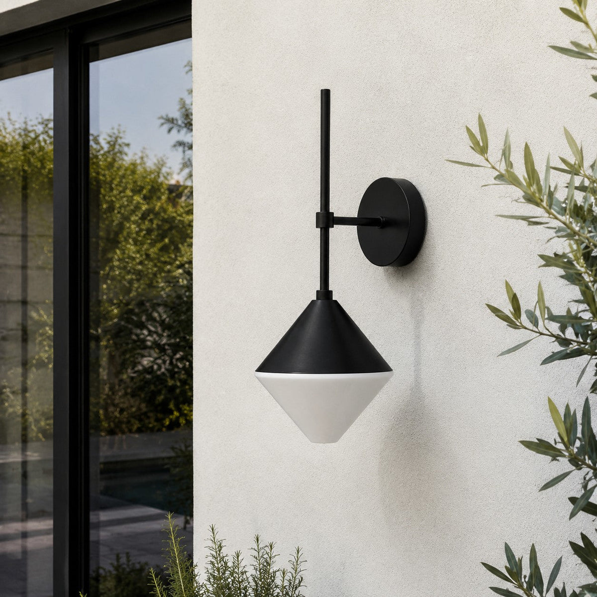 black and white outdoor wall sconce mounted on a garden exterior wall