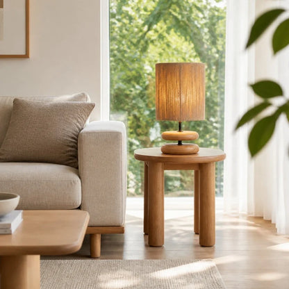 Natural wood table lamp beside a sofa in a bright living room