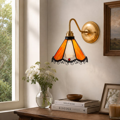 Orange stained glass wall sconce above a window console
