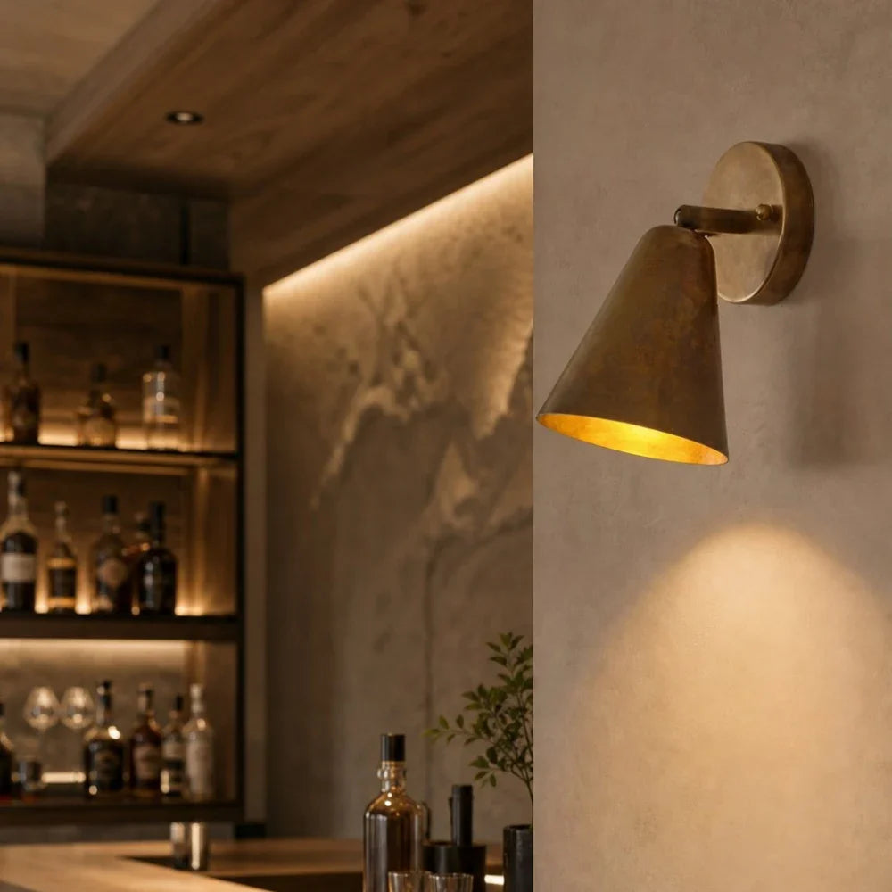Brass cone wall lamp in a warm lounge setting