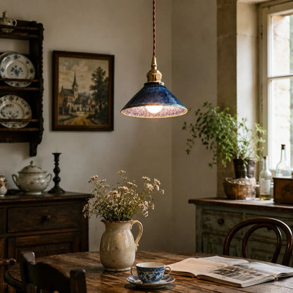 Blue ceramic pendant light installed over a rustic dining table