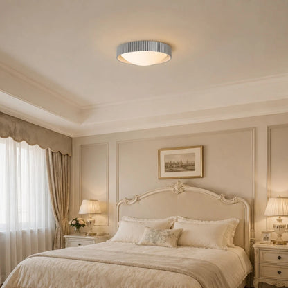 Gray flush mount ceiling light in a soft bedroom setting