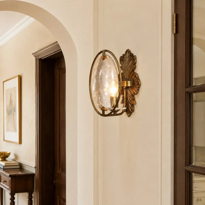 Antique brass glass wall sconce installed in a hallway
