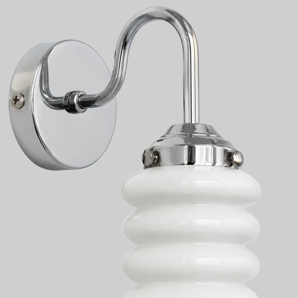 Chrome wall plate and white ribbed glass shade close view