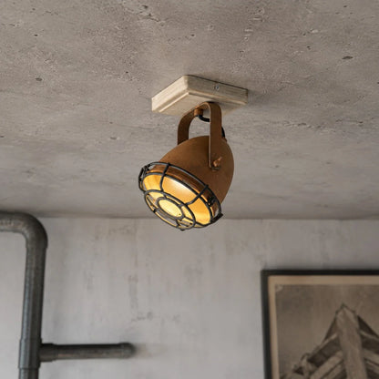 Rust adjustable ceiling spotlight casting a warm GU10 beam