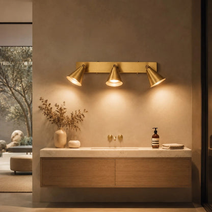 Brass three-head adjustable wall light over a bathroom vanity
