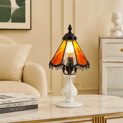 Orange stained glass table lamp styled on a bedside table in a cream bedroom