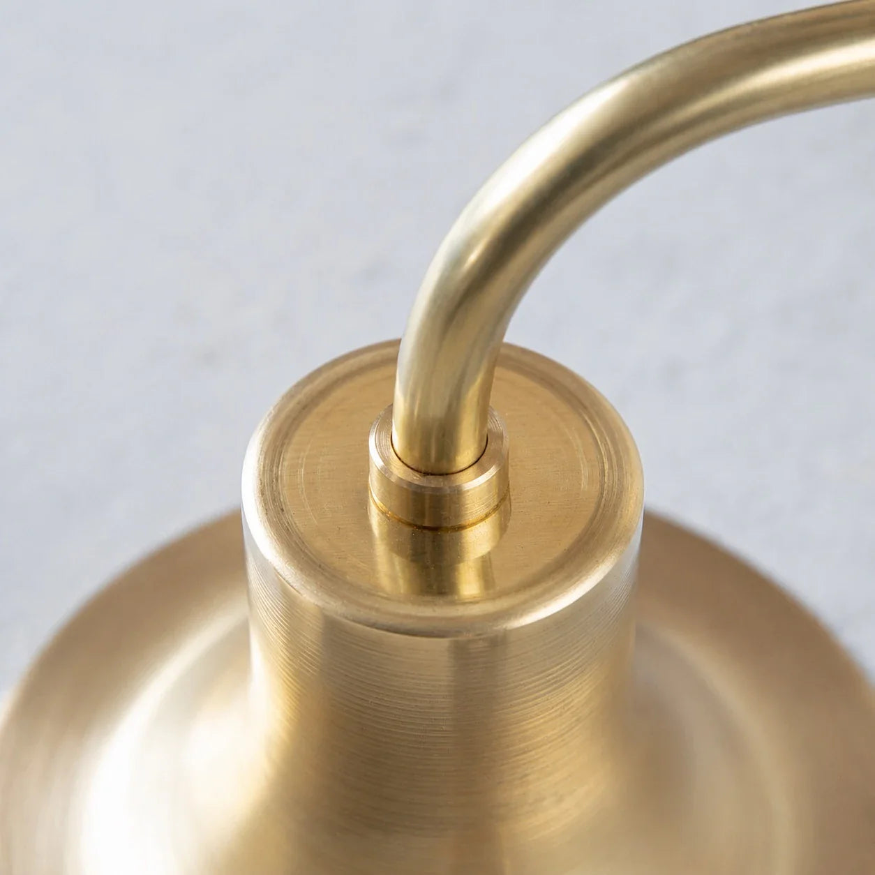 Close-up of curved wall sconce arm and shade connection