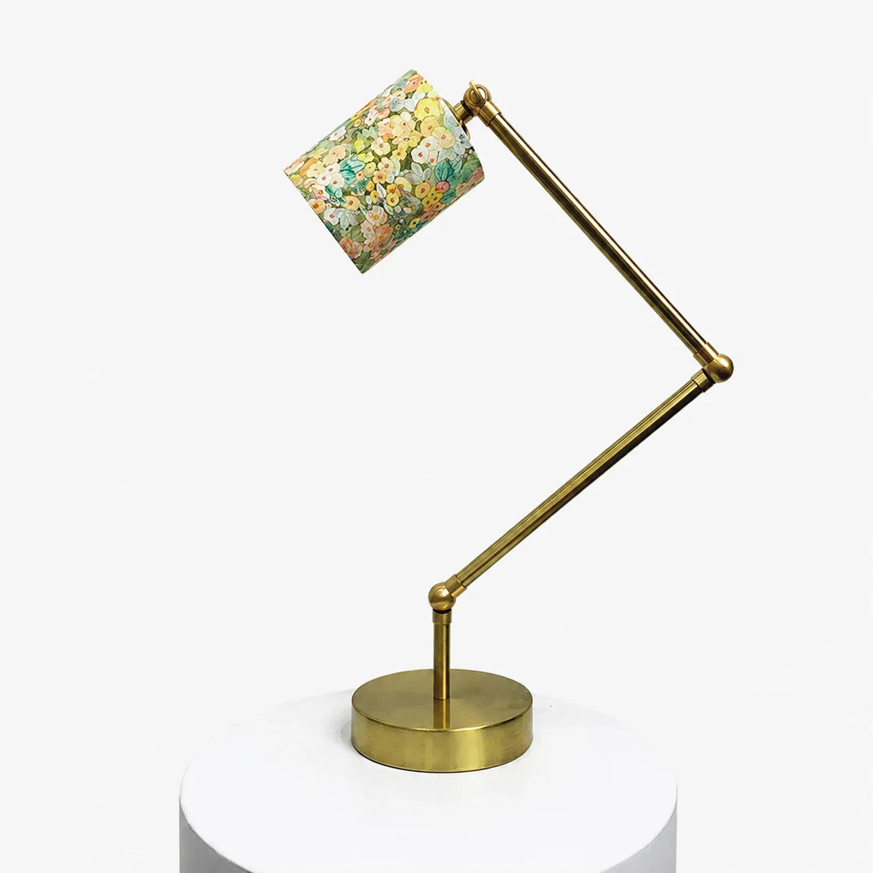 Adjustable brass-tone table lamp with cream garden floral fabric shade