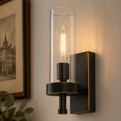 Lit wall sconce beside framed wall art