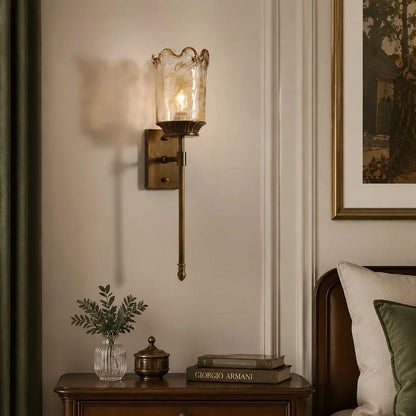 Brass amber glass wall sconce above a console table