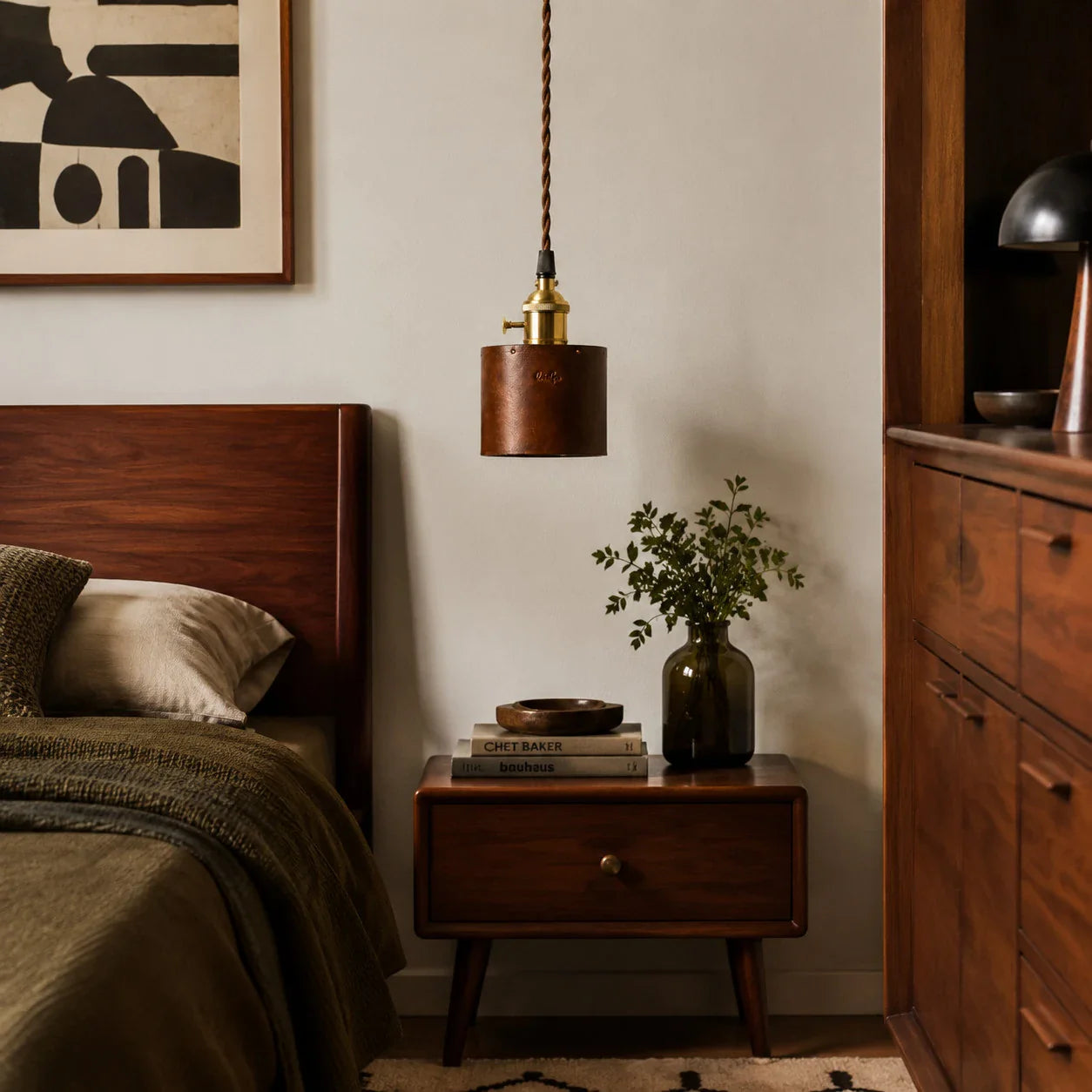 Brown leather pendant lamp above a bedside table